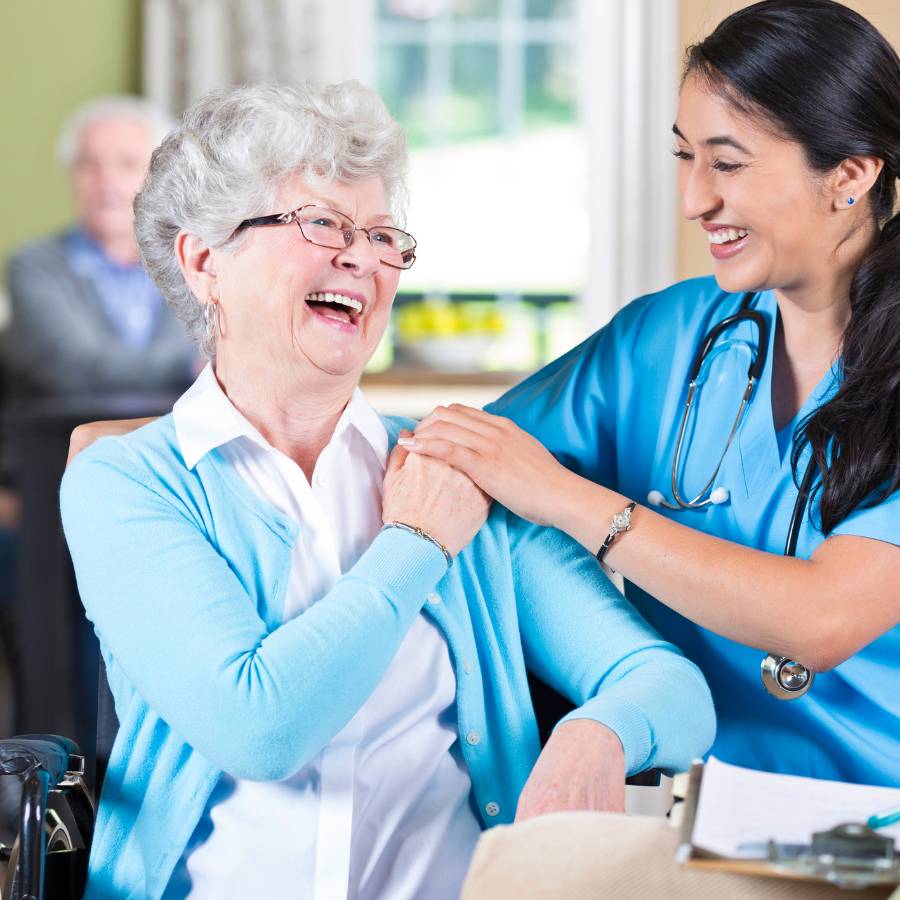 Older woman and younger nurse smiling together